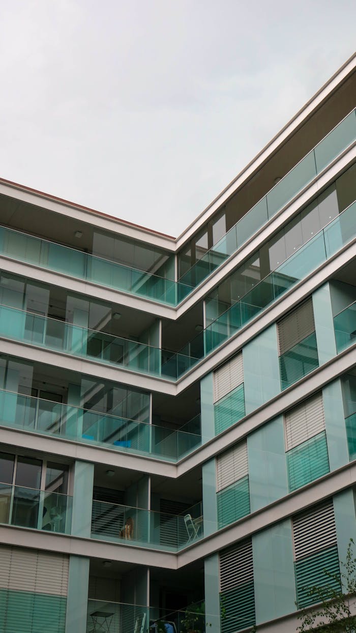Low angle view of a contemporary residential building with glass balconies and sleek design.